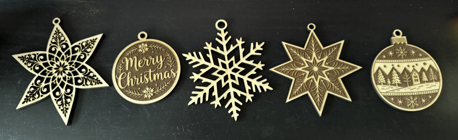 Five laser cut Christmas tree decorations in a row
